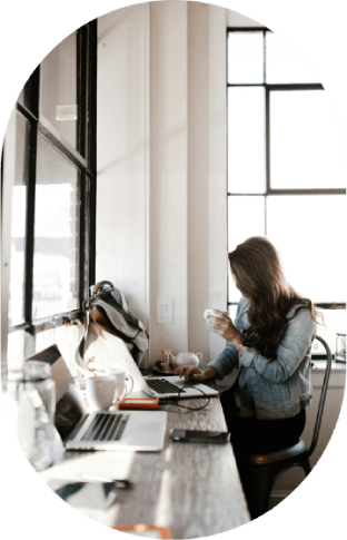 Coffee shop work – Woman working, sipping coffee, using laptop.