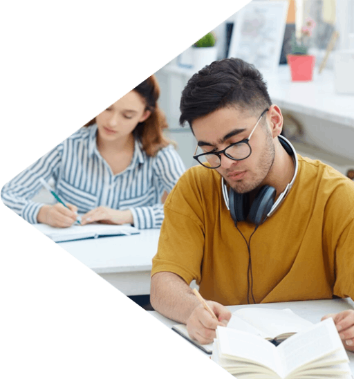 Focused studying – Man with headphones writing in book.